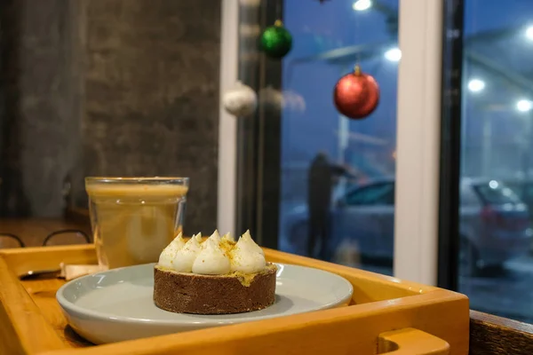 Delicious cheesecake on the background of the cafe Christmas interior on a foggy evening. The cafe is located on a self-service car wash in Lutsk Ukraine. Real-life.