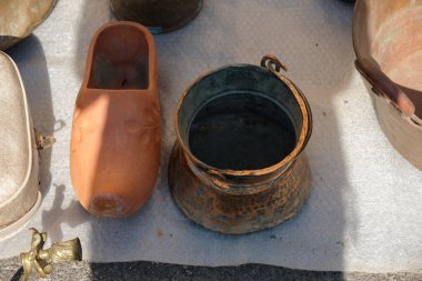 Saplı eski bakır tencere ve Provence 'deki bit pazarında seramik klompen (takunya). Bit pazarı turizmi.