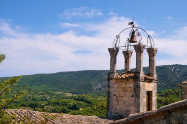 Ortaçağ taşları çan kulesiyle işlenmiş demir çan kulesi. Lacoste, Provence, Fransa.