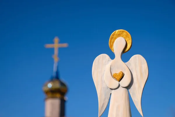 Деревянная Фигура Ангела Золотым Сердцем Руках Фоне Церкви Голубого Неба — стоковое фото