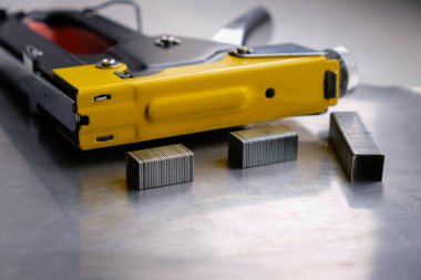 Zımba tabancasındaki metal zımbalar. Gri çelik yüzey.