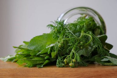 Bir demet papatya çayı ve nane şekeri ahşap mutfak masasında ters çevrilmiş cam bir kavanozda. Yiyecek malzemesi..