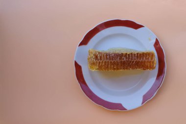 Bal dolu bal petekleri. Tabakta bir parça bal peteği. Üst Manzara. Seçici odaklanma. Boşluğu kopyala.