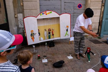 Avignon. Provence. Fransa. 23 Ağustos 2021. Elinde kukla olan bir kuklacı sokaklarda çocuklara gösteri yapıyor..