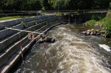 Hayranlar için taş podyum. Kano Kano Slalom. Yeşil ve kırmızı kapıların üstündeki sayılar. Slalom kapılı nehrin vahşiliği. Bad Kreuznach, Almanya.