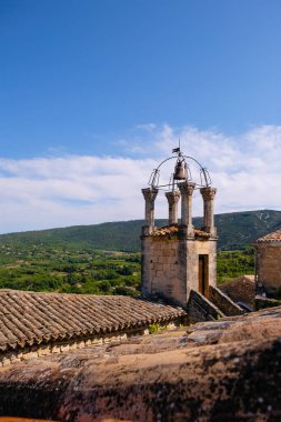 Ortaçağ taşları çan kulesiyle işlenmiş demir çan kulesi. Lacoste, Provence, Fransa. Dikey resim.
