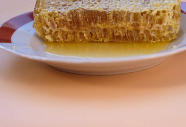 Bal dolu mühürlü bal petekleri. Tabakta bir parça bal peteği. Seçici odaklanma. Boşluğu kopyala.