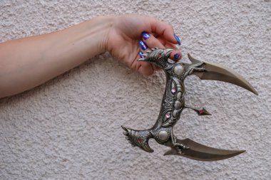 Kadının elinde ninja stili dekoratif saplı bir savaş bıçağı..
