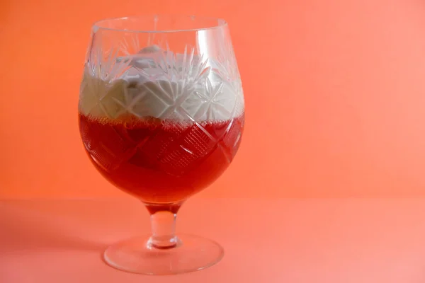 来自红醋栗和酸奶油的果冻 在珊瑚色背景的老式水晶玻璃杯中 复制空间 — 图库照片