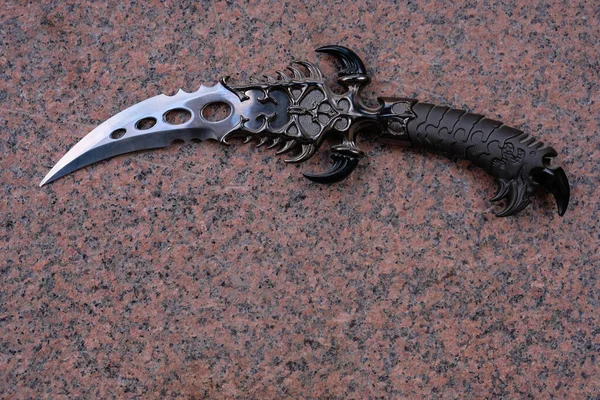 Granit arka planda kavisli bir hançer. Boşluğu kopyala.