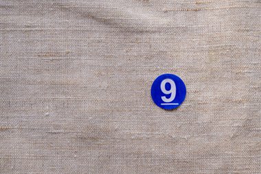 Keten arka planda dokuz numaralı mavi etiket. Boşluğu kopyala.