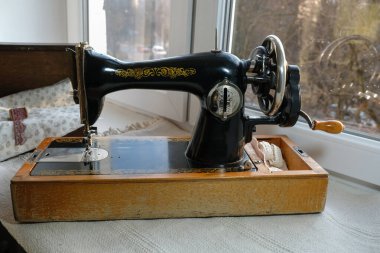 1960 yılının klasik el yapımı dikiş makinesi akşam vakti pencere eşiğinde..