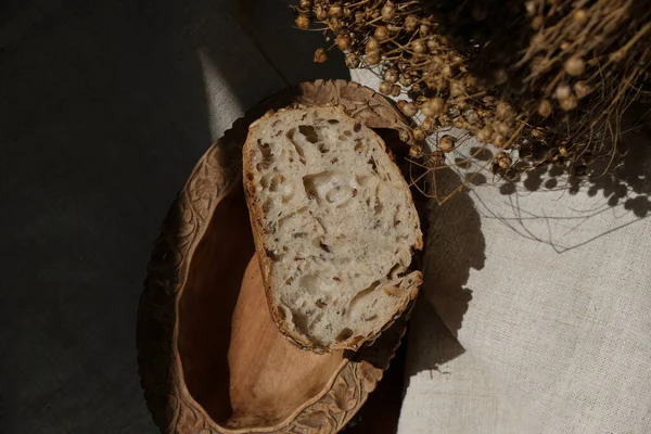 Ketenli ekmek ve kenevir kumaşında ayçekirdeği. Güneş ışığı. Keskin gölgeler. Siyah fotoğraf.