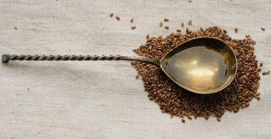 Keten tohumu yağıyla doldurulmuş kaşık. Keten bir arkaplanda keten tohumları.