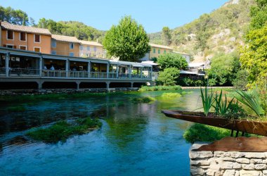 Fontaine de Vaucluse, Provence, France. August 09, 2022. The emerald, crystal-clear Sorgue river, and restaurant background. Famous place.