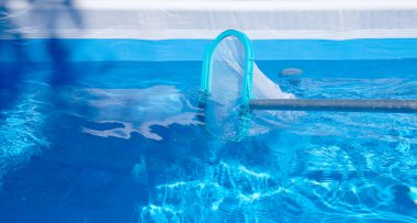 Havuz temizleme ağı. Mavi su arka planı. Boşluğu kopyala.