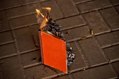 Kağıt kitap yanıp kül olur, beton kiremitler, el yazması yanıklar, ateşle açılan kitap.