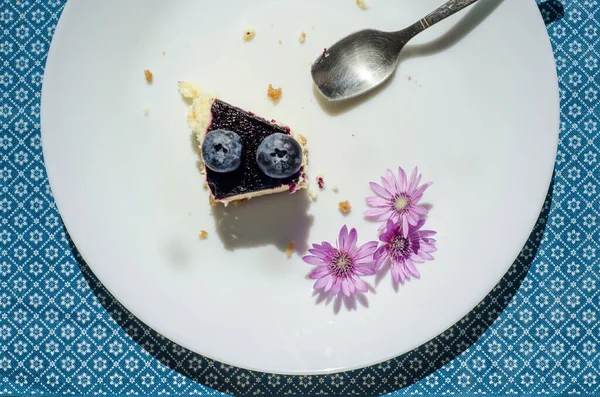 Pedazo Pastel Arándanos Plato Blanco Con Una Cuchara Flores Púrpura — Foto de Stock