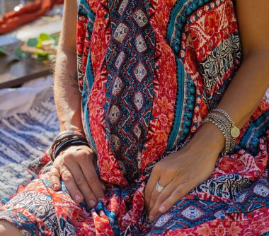 Kırmızı boho tarzı hamile kadın kolları ve midesi