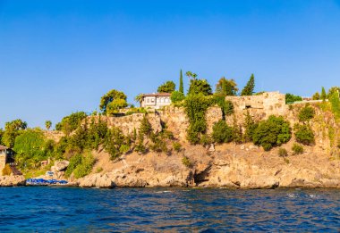 deniz ve dağ manzaralı evler ve ağaçlarla