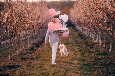 Kız elinde bir oyuncak bebek tutuyor. O bir maske takıyor. Bahar geldi..