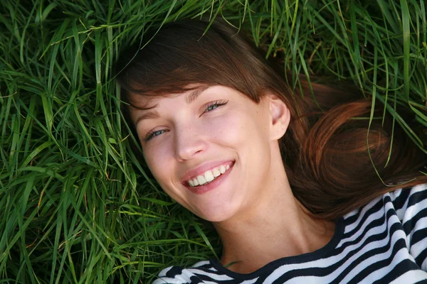 Smiling girl laying on grass — Stock Photo, Image