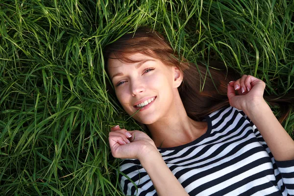 Smiling girl laying on grass — Stock Photo, Image