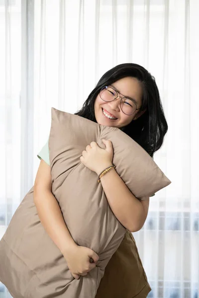 Gözlüklü Güzel Asyalı Kadın Yastığına Sarılıyor Yatak Odasındaki Kameraya Gülümsüyor — Stok fotoğraf