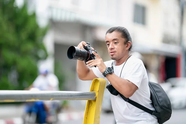 专业的亚洲摄影师带着他的无镜像相机 在室外露天剧场外的街道上专注于这一形象 — 图库照片