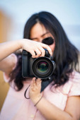 Amatéři sluneční brýle asijské žena pořídit fotografii s profesionálním zrcadlem bez kamery na venkovní modré střechy budovy v soumraku.