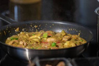 Kapalı Tavuklu Yeşil Köri tavada kızartıldı ve tavada kaynatıldı.