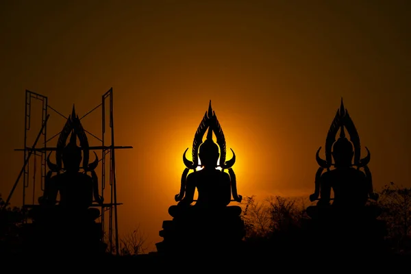 太陽が沈む屋外フィールドと夕暮れの期間で タイを作成し 構築プロセスの間Silhouette仏像 — ストック写真