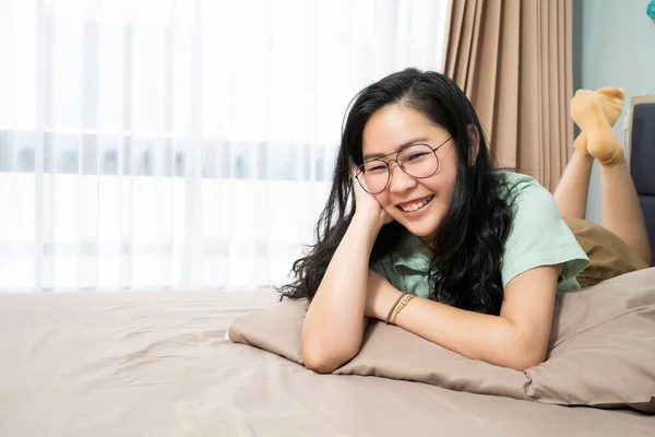 Óculos Bonitos Mulher Asiática Está Deitada Seu Estômago Olha Para — Fotografia de Stock