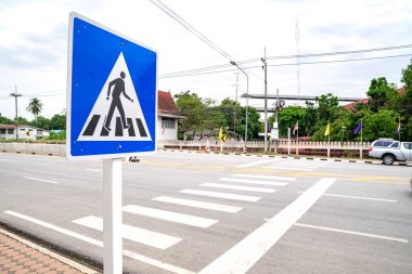 Tayland 'ın Uthai Thani eyaletinin kırsal kesimlerinde yol üzerindeki yaya geçidinde veya zebra tabelasında bulunan boş insanlar ve yolcular, inşaat ve çevre alanlarında yaşayan yerel halkla birlikte.