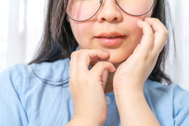 Yüzü pürüzsüz yüzlü ve seksi dudaklı Asyalı kadının yarı yüzü..