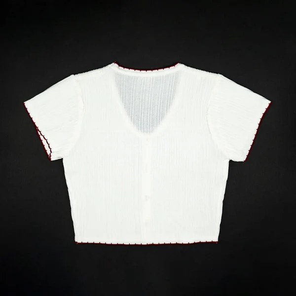 平整的白色针织衫T恤衫 衬边上有红线 背景为黑色 在演播室灯光下 — 图库照片