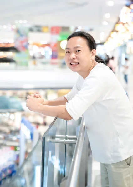 アジア タイのロングヘア白いTシャツの男がデパートに立っている — ストック写真