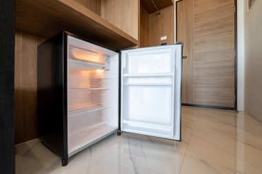 Ahşap tezgahın altında küçük bir buzdolabı açtı ve otel ve tatil yerindeki delux odasına girdi..