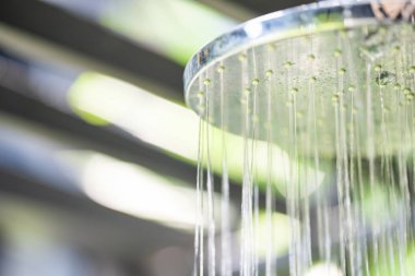Outdoor pool bathroom open air style  with rain shower beside swimming pool in sunny day.