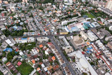 Aerial view of a large city There are many houses arranged in proportions which have a road cut through and a little green area.