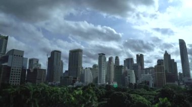 Timelapse of Building with Green area in front of the middle of Bangkok metropolis with high building all around in the open sky. 
