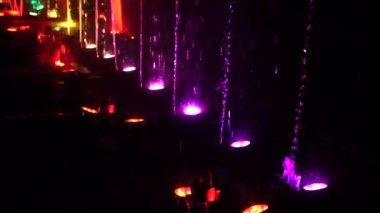 Gece su yüzeyinde gözyaşları, ışıklandırma ışığı ile süslenmiş ve oynanmış..