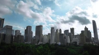Timelapse of Building with Green area in front of the middle of Bangkok metropolis with high building all around in the open sky. 