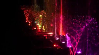 Gece su yüzeyinde gözyaşları, ışıklandırma ışığı ile süslenmiş ve oynanmış..