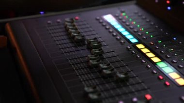 DJ hand and finger are closed up between he controls the Mixer Sound Console board Machine.
