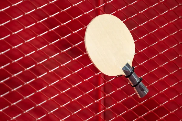 one Table Tennis Paddle racket is hung on red grill by a cable tie for display in exhibition sports event