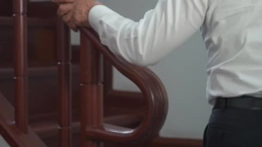 backside of Senior Business man walking on the wood stair