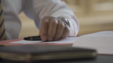 Lawyer is working, opening, reading report on his table with concentration.