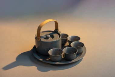 Yeni çağdaş modern ve klasik kombinasyon tarzına sahip çay kabı seramik seti düz taş mutfak tezgahında, pencereden gelen güneş ışığı.