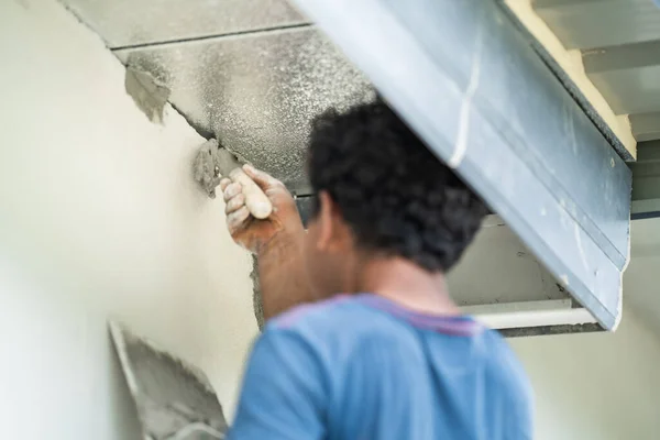 Close up to Plastering from Asian man\'s hand who plaster the top of the wall to protect insect and rat enter into the inside.